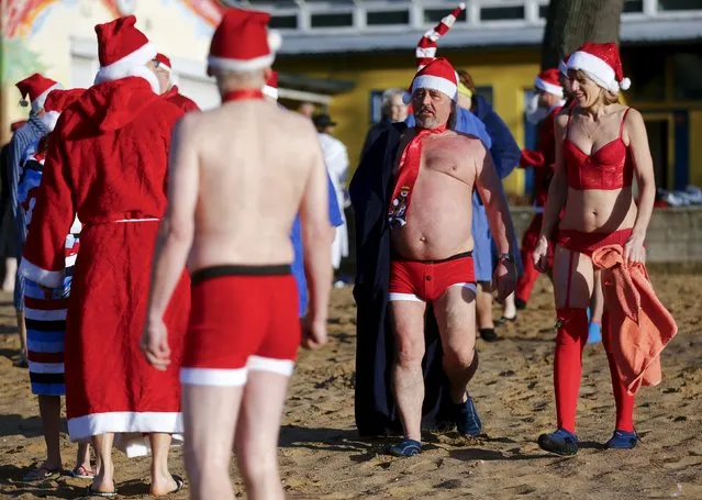 Members of the ice swimming club “Berliner Seehunde” (Berlin Seals) prepare to take a dip in the Orankesee lake as part of their traditional Christmas swimming session in Berlin, Germany, December 25, 2015. (Photo by Hannibal Hanschke/Reuters)