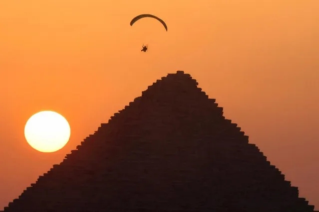 A man flies a paramotor above the Pyramids, in Giza, on the outskirts of Cairo, Egypt on June 16, 2023. (Photo by Mohamed Abd El Ghany/Reuters)