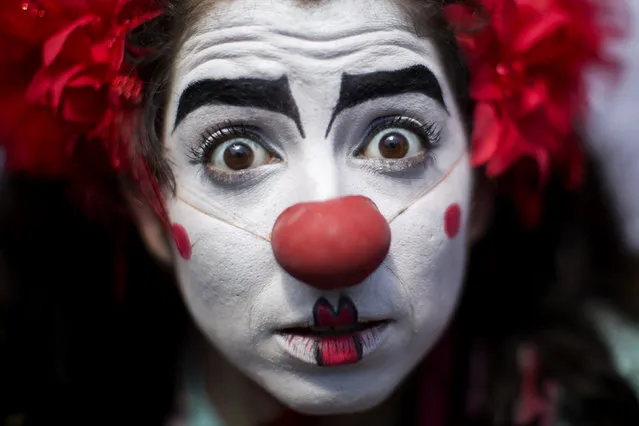 A reveler dressed as a clown jokes during the “Gigantes da Lira” carnival parade in Rio de Janeiro, Brazil, Sunday, February 8, 2015. (Photo by Felipe Dana/AP Photo)