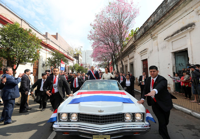 Paraguay's new President Mario Abdo Benitez waves to the public as he rides in an open car alongside Paraguay's first lady Silvana Lopez Moreira after his inauguration ceremony in Asuncion, Paraguay on August 15, 2018. (Photo by Marcos Brindicci/Reuters)