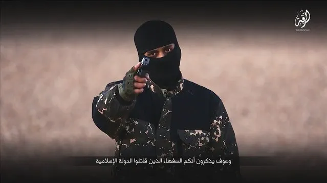 A masked man points a weapon as he speaks in this still image from a handout video obtained on January 4, 2016 from a social media website which has not been independently verified. Britain was on Monday examining the Islamic State video showing a young boy in military fatigues and an older masked militant who both spoke with British accents. The propaganda video, which could not be independently verified, also shows the killing of five men accused of spying for the West. (Photo by Reuters/Social Media)