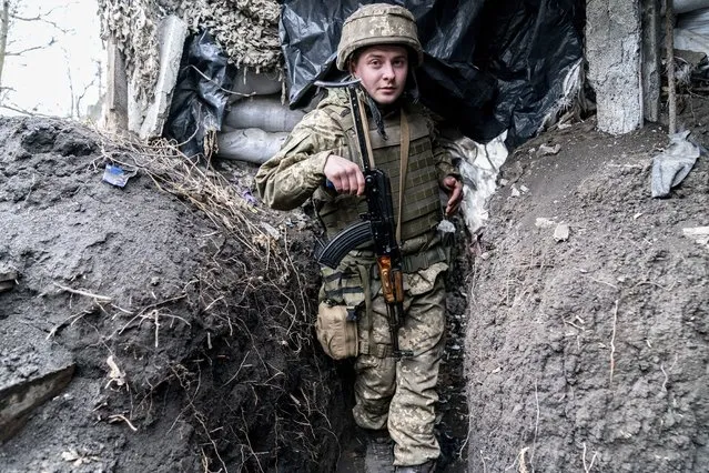 Ukrainian serviceman Serhiy Kochuk walks along a trench near the front-line town of Krasnohorivka, eastern Ukraine, Friday, March 5, 2021. In the front-line town of Krasnohorivka, soldiers widely refuse to vaccinate. “I have little faith in a pandemic, I don't think it's some kind of serious disease”, said Serhiy Kochuk, a 25-year-old soldier who has been on duty at the front line. “I am healthy, but the vaccine can provoke illness; because of this vaccine you can get sick”. (Photo by Evgeniy Maloletka/AP Photo)