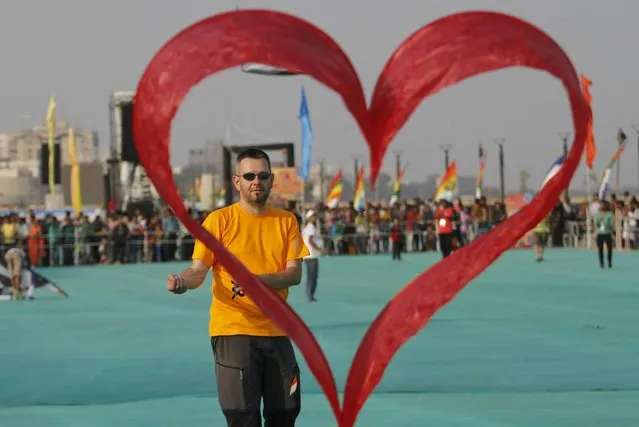 A kite flyer from Switzerland flies his heart shaped kite during international kite festival in Ahmadabad, India, Monday, January 11, 2016.The event is scheduled to run till Thursday. (Photo by Ajit Solanki/AP Photo)
