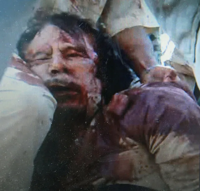 A man purported to be Libyan leader Muammar Gaddafi is seen in this still image taken from video footage October 20, 2011. Gaddafi was killed on Thursday as Libya's new leaders declared they had overrun the last bastion of his long rule, sparking wild celebrations that eight months of war may finally be over. Details of the death near Sirte of the fallen strongman were hazy but it was announced by several officials of the National Transitional Council (NTC) and backed up by a photograph of a bloodied face ringed by familiar, Gaddafi-style curly hair. (Photo by Reuters TV)