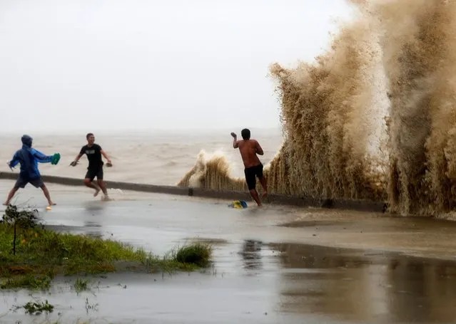 Filipinos frolic on waves in the typhoon-hit town of Aparri, Cagayan province, Philippines, 15 September 2018. Mangkhut, the most powerful typhoon to strike the Philippines in the last five years, made landfall in the northeastern town of Baggao with maximum sustained winds of 205 km/h (128 mph) and gusts of up to 285 km/h (177 mph). (Photo by Francis R. Malasig/EPA/EFE/Rex Features/Shutterstock)