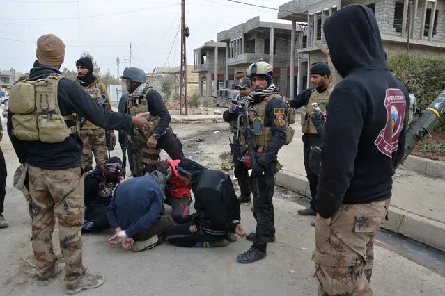 Handcuffed men, who according to the Iraqi security forces are suspected Islamic State militants, are seen in Eelam neighborhood east of Mosul, Iraq, December 8, 2016. (Photo by Reuters/Stringer)