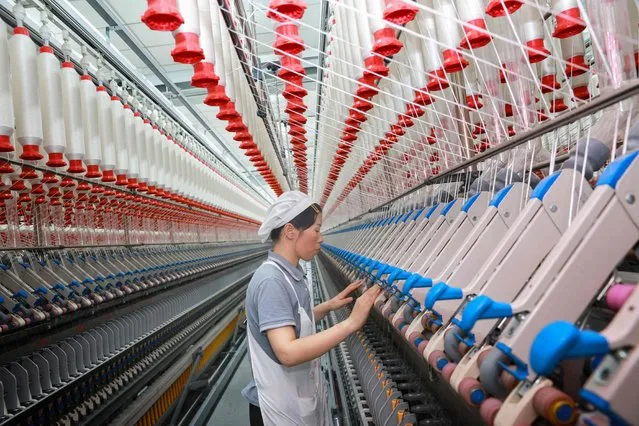 A worker operates machines at a texile factory in Nantong, in eastern China's Jiangsu province on September 14, 2023. (Photo by AFP Photo/China Stringer Network)