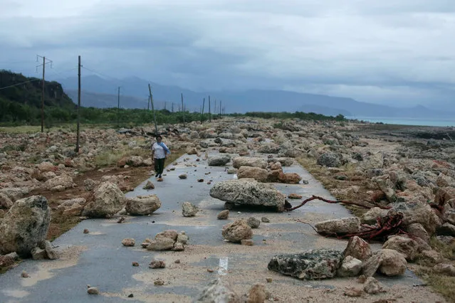 A woman walks on a highway blocked by rocks after the passage of hurricane Matthew on the coast of Guantanamo province, Cuba, October 5, 2016. (Photo by Alexandre Meneghini/Reuters)