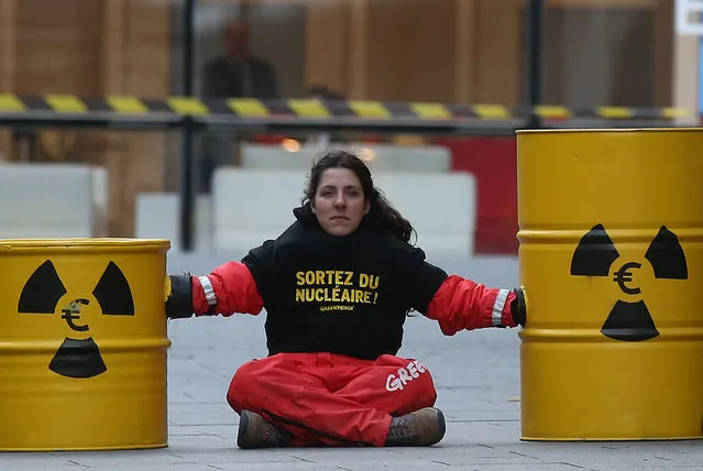 A Greenpeace activist blocks the entrance of the France's state-owned electricity company EDF  headquarters to protest against nuclear energy safety in Paris, France, December 14, 2016. (Photo by Jacky Naegelen/Reuters)