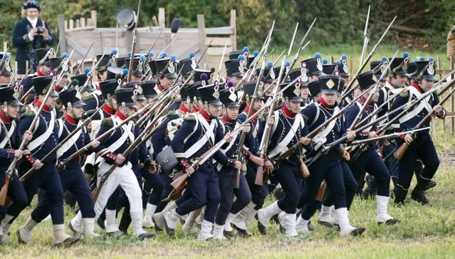 Performers wearing 19th century French military uniforms attack Allied Forces performers during a reenactment of the Battle of the Nations, in a field in the village of Markkleeberg near Leipzig October 20, 2013. The east German city of Leipzig commemorated the 200th anniversary of the largest battle of the Napoleonic Wars on Sunday by reenacting the Battle of the Nations, with 6,000 military-historic association enthusiasts from all over Europe. The decisive encounter in which tens of thousands of soldiers were killed, took place from October 17-19, 1813, just outside of Leipzig.  At the height of the hostilities Napoleon fielded more than 200,000 men against an Allied force of some 360,000 soldiers which included troops from Russia, Austria, Prussia and Sweden. (Photo by Fabrizio Bensch/Reuters)