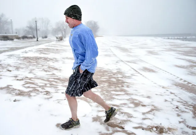 Todd Strickland of Madison walks back to his car from the beach at Savin Rock in West Haven, Connecticut, Saturday, January 23, 2016 after the 16th Annual Icy Plunge for the Cure was postponed until February due to bad weather. Connecticut Gov. Dannel Malloy is encouraging residents in the southern part of the state to stay off the roads as a snowstorm moves across the region. Malloy in a statement Saturday afternoon said his office was “closely monitoring storm conditions”. (Photo by Arnold Gold/New Haven Register via AP Photo)
