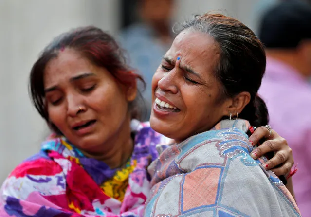 Women mourn the death of a relative after a commuter train traveling at high speed ran through a crowd of people on the rail tracks on Friday, outside a hospital in Amritsar, India, October 20, 2018. (Photo by Adnan Abidi/Reuters)