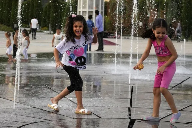 Children enjoy a water fountain at the Ebrahim Park while temperature reaches 38 C (100.4 F) in Tehran, Iran, Tuesday, August 1, 2023. (Photo by Vahid Salemi/AP Photo)