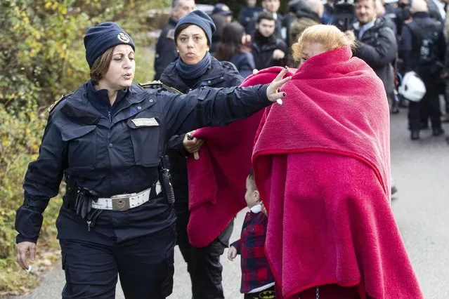 A woman evicted from one of eight illegally built villas belonging to members of the Casamonica criminal clan, is escorted by two police officers, in Rome, Tuesday, November 20,  2018. Rome city authorities sent in 600 police officers to evict a purported crime family from eight villas that were allegedly built without authorization decades ago. (Photo by Massimo Percossi/ANSA via AP Photo)