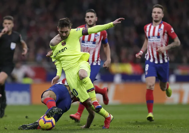 Barcelona's Lionel Messi, front right, duels for the ball with Athletico Madrid's Rodri during a Spanish La Liga soccer match between Atletico Madrid and FC Barcelona at the Metropolitano stadium in Madrid, Saturday, November 24, 2018. (Photo by Manu Fernandez/AP Photo)