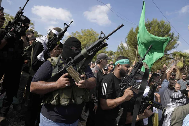 Palestinian militants attend a funeral of people killed during an Israeli military raid on a Palestinian refugee camp, Nur Shams, in the West Bank on Friday, October 20, 2023. (AP Photo/Majdi Mohammed)