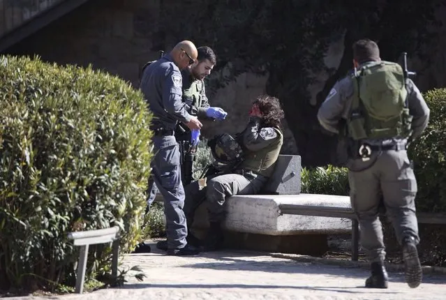 An Israeli border policewoman is being attended by others at the scene where three Palestinians were shot dead by Israeli police after carrying out what Israeli police spokesman said was a shooting and stabbing attack outside Damascus gate to Jerusalem's old city February 3, 2016. (Photo by Fayez Abu Rumaila/Reuters)