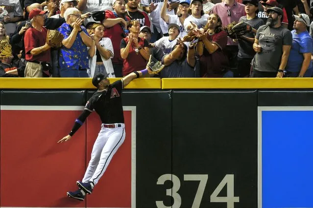 Arizona Diamondbacks left fielder Lourdes Gurriel Jr. reaches for the ball that is caught by a fan off of Texas Rangers second baseman Marcus Semien’s home run during the third inning of game four of the Major League Baseball (MLB) World Series between the  Arizona Diamondbacks and the Texas Rangers at Chase Field in Phoenix, Arizona, USA 31 October 2023. The World Series is the best-of-seven games. (Photo by John G. Mabanglo/EPA)
