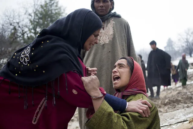 An unidentified woman, left, comforts a relative of landslide victims in village of Laden some 45 Kilometers (28 miles) west of Srinagar, Indian-controlled Kashmir, Monday, March 30, 2015. (Photo by Dar Yasin/AP Photo)