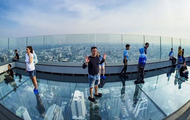 People on the “glass tray”, a glass overlook that sticks out over the south edge of the Maha Nakhon Tower in Bangkok, Thailand on December 27, 2018. The MahaNakhon Skywalk, at the top of the King Power Maha Nakhon Tower, is 1,030 feet (314 meters) above street level. It is the tallest building and highest vantage point in Bangkok. (Photo by Sean Edison/ZUMA Wire/Rex Features/Shutterstock)