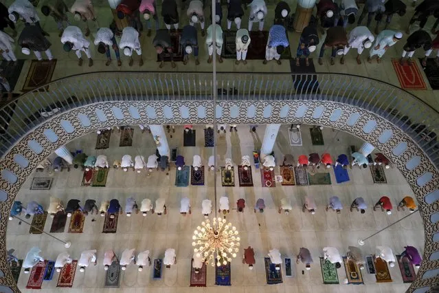 Muslims offer prayers on the morning of Eid-ul-Adha at Baitul Mukarram National Mosque in Dhaka, Bangladesh, July 21, 2021. Eid al-Adha, or the Feast of the Sacrifice, is marked by sacrificing animals to commemorate the prophet Ibrahim's faith in being willing to sacrifice his son. (Photo by Mahmud Hossain Opu/AP Photo)