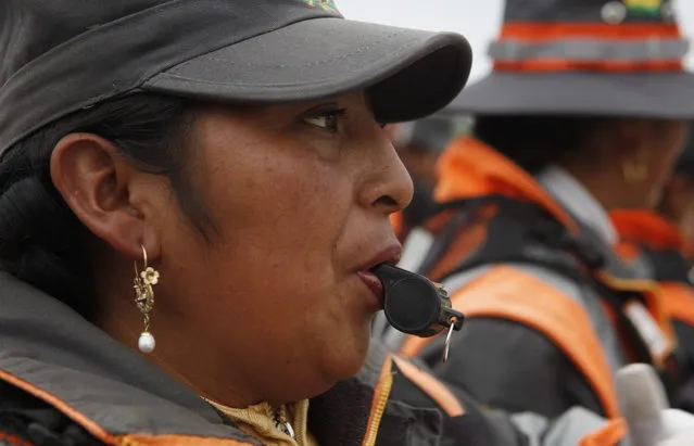 In this December 13, 2013 photo, an Aymara traffic policewomen learns to use a whistle to control and direct traffic during a training session in El Alto, Bolivia. (Photo by Juan Karita/AP Photo)