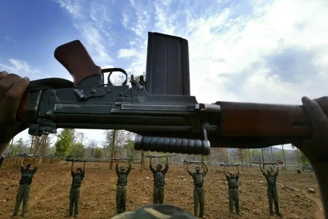 In this April 13, 2007 file photo, Maoist rebels or Naxalites, raise their arms during an exercise at a temporary base in the Abujh Marh forests, in the central Indian state of Chhattisgarh. Indian police say government forces have killed at least 14 Maoist rebels during a raid on their hideout in a forested area in western India. (Photo by Mustafa Quraishi/AP Photo)