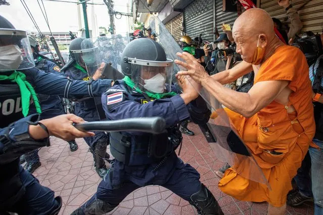 A protester clashes with riot police officers during a protest against the Asia-Pacific Economic Cooperation (APEC) Summit 2022, near the Democracy Monument in Bangkok, Thailand on November 18, 2022. (Photo by Tanat Chayaphattharitthee/Reuters)