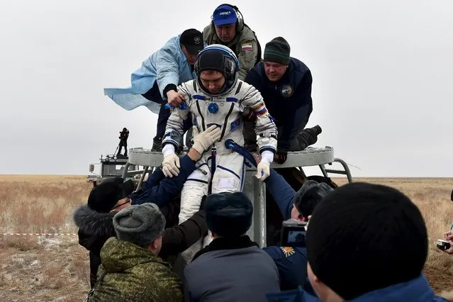 Ground personnel help Russian cosmonaut Sergei Volkov to get out of a Soyuz capsule shortly after landing near the town of Dzhezkazgan (Zhezkazgan), Kazakhstan, March 2, 2016. (Photo by Kirill Kudryavtsev/Reuters)