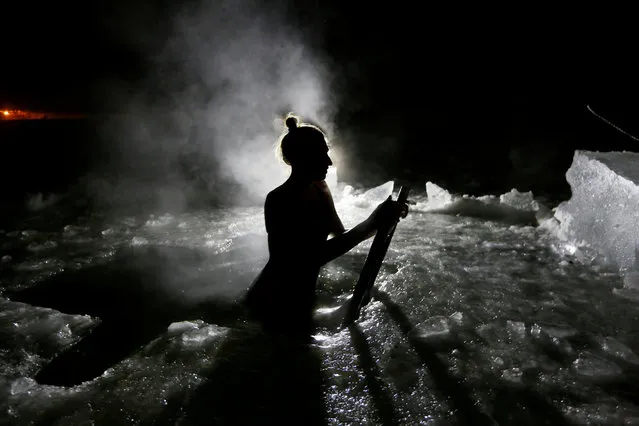 A woman takes a dip in the icy waters of the Yenisei River during celebrations of the Orthodox Christian feast of Epiphany outside Krasnoyarsk, Russia on January 19, 2019. (Photo by Ilya Naymushin/Reuters)