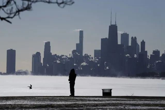 A woman bundles up as she looks to the Lake Michigan at Montrose beach in Chicago, Tuesday, January 16, 2024. Millions of Americans face below-zero temperatures as storms bring blast of Arctic air, snow and ice. (Photo by Nam Y. Huh/AP Photo)
