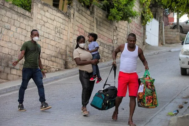 Jean Charles Celestin, right, carries luggage belonging to his cousin Jhon Celestin, left, Jhon's wife Delta De Leon, and their daughter Chloe, in Port au Prince, Haiti, Wednesday, September 22, 2021. Jhon Celestin arrived in Haiti aboard the last flight Wednesday to the Haitian capital, a city the 38-year-old left three years ago in search of a better-paying job to help support his family. (Photo by Joseph Odelyn/AP Photo)