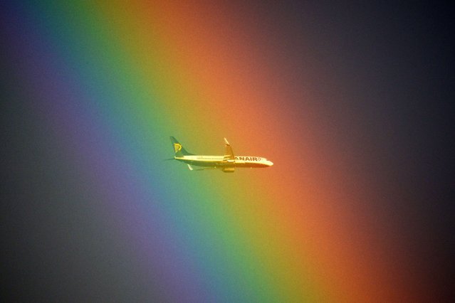 A plane of the Irish low cost company Ryanair flies in front of a rainbow over Rome on January 19, 2014. (Photo by Gabriel Bouys/AFP Photo)