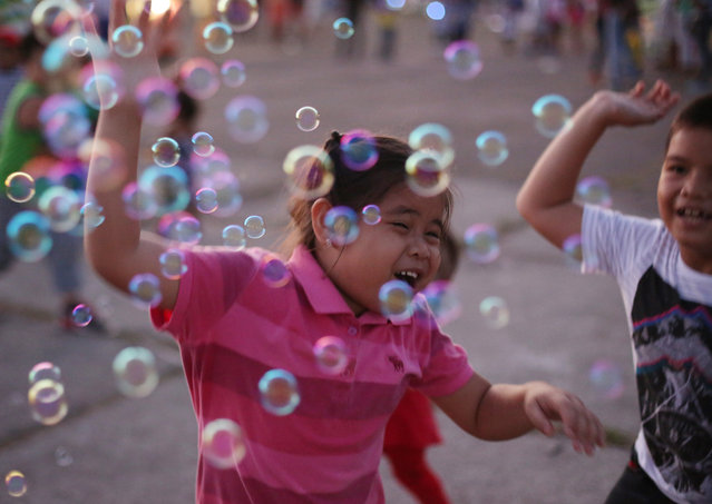 Filipino children play with bubbles at a public park as the long Christmas season holidays come to an end in this largely Roman Catholic nation on Sunday, January 3, 2016, in suburban Quezon city, north of Manila, Philippines. (Photo by Aaron Favila/AP Photo)