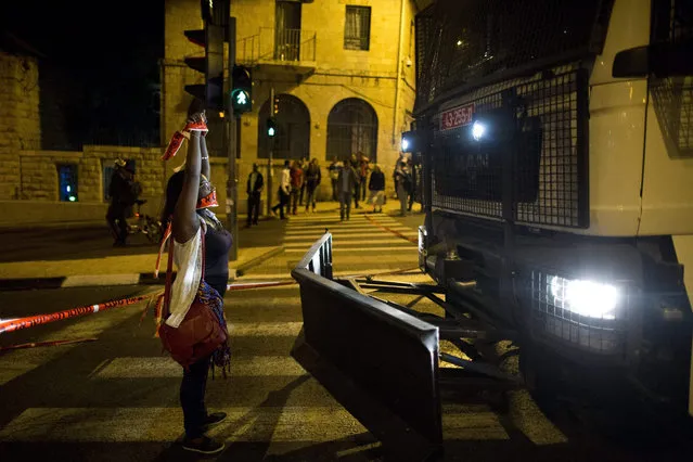 A protester blocks a police vehicle during a protest by Israelis of Ethiopian origin against racism and what they say is excessive aggression by Israeli police as they try to march to the Prime Minister's Residence in Jerusalem, Israel, 30 April 2015. Demonstrators gathered in protest in response to a video posted online allegedly showing Israeli border policemen assaulting an Israeli Ethiopian soldier. (Photo by Abir Sultan/EPA)