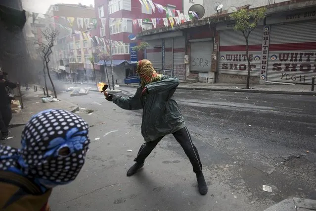 A protester throws a Molotov cocktail during clashes with police in Okmeydani neighborhood in Istanbul, Turkey, May 1, 2015. (Photo by Kemal Aslan/Reuters)