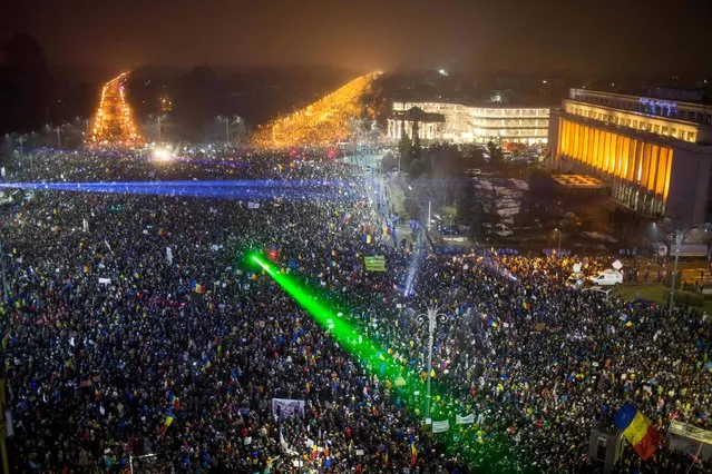 This picture shows a large view of people protesting against the Romanian government's contentious corruption decree in front of the government headquarters at the Victoriei square in Bucharest on February 5, 2017. Romania's government formally repealed contentious corruption legislation that has sparked the biggest protests since the fall of dictator Nicolae Ceausescu in 1989, ministerial sources said. The emergency decree, announced on Tuesday (January 31, 2017), would have decriminalised certain corruption offences, raising concerns in Romania and outside that the government was easing up on fighting graft. Centre-right President Klaus Iohannis, elected in 2014 on an anti-graft platform, previously had called the decree “scandalous” and moved to invoke the constitutional court. (Photo by Andrei Pungovschi/AFP Photo)