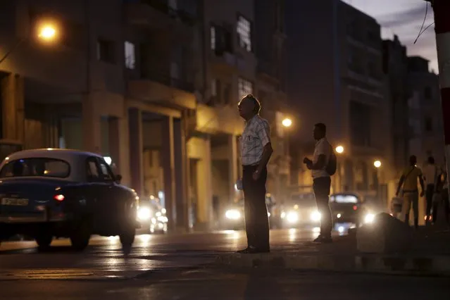 People wait for transportation while standing on a street in Havana, March 17, 2016. (Photo by Ueslei Marcelino/Reuters)