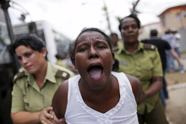 A member of the “Ladies in White” dissident group shouts as she is led away by police officers after they broke up a regular march of the group, detaining about 50 people, hours before U.S. President Barack Obama arrives for a historic visit, in Havana, Cuba March 20, 2016. (Photo by Ueslei Marcelino/Reuters)