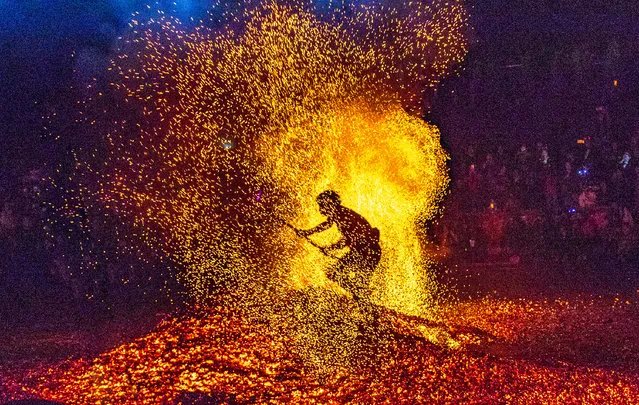 A man performs a stunt by walking barefoot around the burning charcoal to celebrate the Double Ninth Festival at Pan'an County on October 17, 2018 in Jinhua, Zhejiang Province of China. The Double Ninth Festival (Chongyang Festival), a day to pay respect to seniors, falls on October 17 this year. (Photo by VCG/VCG via Getty Images)