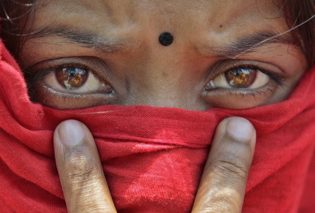 A worker of the recently closed Swan garments factory covers her face with a scarf to shelter herself from the sun as she participates in a protest outside the Bangladesh Garment Manufacturers and Export Association (BGMEA) office in Dhaka, Bangladesh, Monday, May 4, 2015. More than two hundred workers protested Monday demanding payment of wages still owed to them as well as reopening of the manufacturing unit. (Photo by A. M. Ahad/AP Photo)
