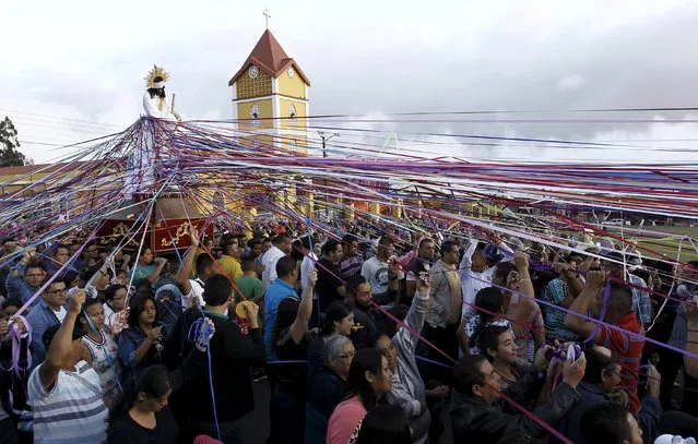Catholics carry a statue of Jesus Nazareno in a procession known as “Jesus Nazareno of the tapes” during Holy Week in Cot de Cartago, Costa Rica March 23, 2016. People tie ribbons to the statue to symbolize promises they make to Jesus. (Photo by Juan Carlos Ulate/Reuters)