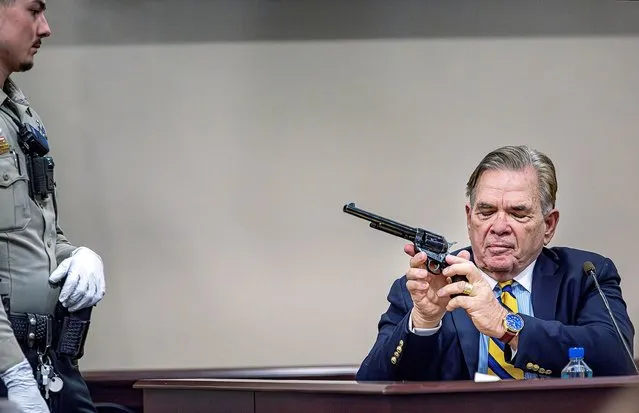 As Santa Fe County Deputy Levi Abeyta (left) watches, Expert witness for the defense Frank Koucky III demonstrates how to uncock a gun like the one used in the Rust shooting during testimony in Hannah Gutierrez-Reed's involuntary manslaughter trial at the First Judicial District Courthouse in Santa Fe on Tuesday, March 5, 2024. (Photo by Jim Weber/Pool via Reuters)