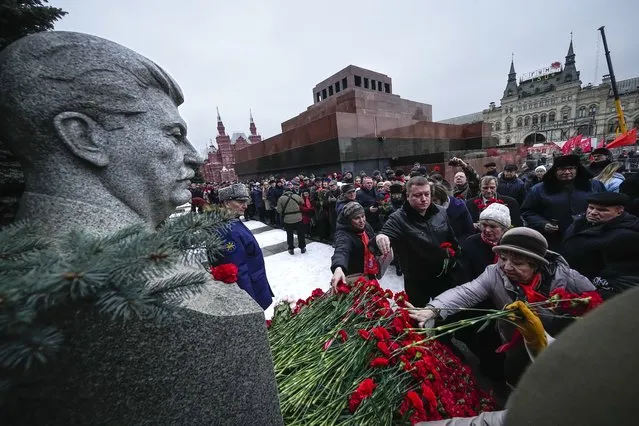 Communist party supporters lineup to place flowers at Josef Stalin's grave near the Kremlin Wall to mark the 71st anniversary of his death with the Mausoleum of the Soviet founder Vladimir Lenin in the background, in Red Square in Moscow, Russia, Tuesday, March 5, 2024. Josef Stalin led the Soviet Union from 1924 until his death in 1953. (Photo by Alexander Zemlianichenko/AP Photo)