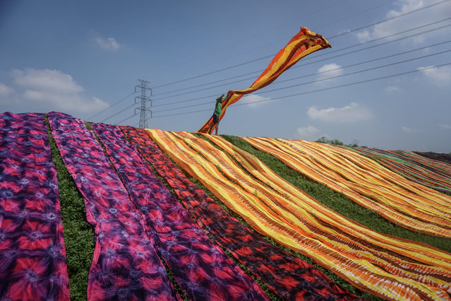 A worker throws a cloth during a drying process at Sukoharjo near Solo, Central Java province, Indonesia, April 23, 2019 in this photo taken by Antara Foto. (Photo by Mohammad Ayudha/Antara Foto via Reuters)