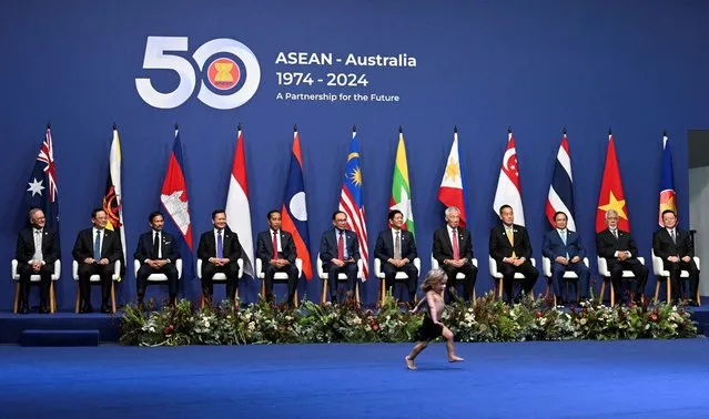 A child runs as Australia's Prime Minister Anthony Albanese,  Laos' Prime Minister Sonexay Siphandone, Brunei's Sultan Hassanal Bolkiah, Cambodia's Prime Minister Hun Manet, Indonesia's President Joko Widodo, Malaysia's Prime Minister Anwar Ibrahim, Philippines President Ferdinand Marcos Jr, Singapore's Prime Minister Lee Hsien Loong, Thailand's Prime Minister Srettha Thavisin, Vietnam's Prime Minister Pham Minh Chinh, Prime Minister of Timor-Leste Xanana Gusmao and Secretary-General of ASEAN, Dr Kao Kim Hourn sit for a family photo at the ASEAN-Australia Special Summit, in Melbourne, Australia on March 5, 2024. (Photo by Jaimi Joy/Reuters)