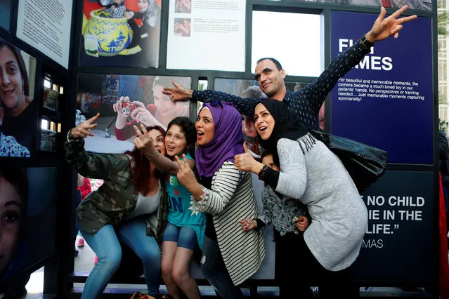 People pose for a picture with a cancer patient (2nd L) in front of her photographs and other cancer patients' photographs during an exhibition for Children's Cancer Center (CCCL) in Zaitunay Bay in Beirut, Lebanon April 11, 2016. (Photo by Mohamed Azakir/Reuters)