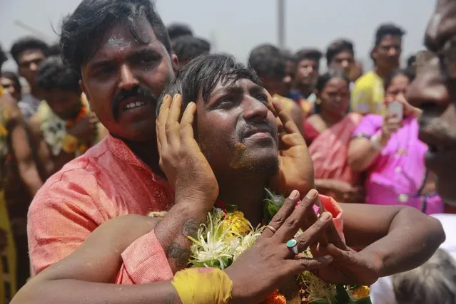 An Indian Tamil Hindu devotee offers prayers before being  pierced with a metal spear at a religious procession during Muthu Mariamman Puja festival in Mumbai, India, Tuesday April 19, 2016. Devotees perform acts of self- affliction to seek blessings of Hindu goddess Mariamman. (Photo by Rafiq Maqbool/AP Photo)