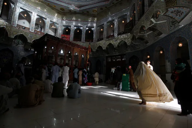 A woman clad in burqa walks in the hallway of the tomb of Sufi saint Syed Usman Marwandi, also known as Lal Shahbaz Qalandar, in Sehwan Sharif, in Pakistan's southern Sindh province, September 5, 2013. (Photo by Akhtar Soomro/Reuters)
