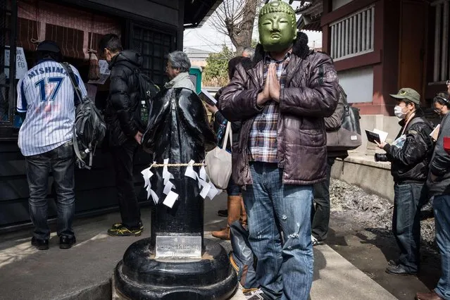 A participant prays near a giant phallus during the Kanamara Matsuri Steel Phallus Festival at Kawasaki, Japan on April 2, 2017. (Photo by DELETREE/SIPA Press/Rex Features/Shutterstock)